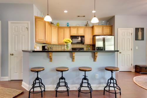 a kitchen with wooden cabinets and bar stools at Shared Game Room and Lake Access Hiram Apartment in Hiram