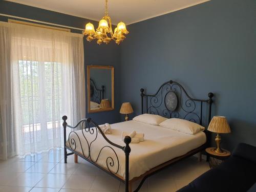 a bedroom with a bed and a mirror and a chandelier at Belfiore house in Valverde