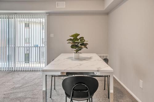 a white table with a potted plant on top of it at Spacious Retreat I Balcony I Parking I Chateau in Wilmington
