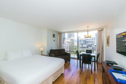 a hotel room with a bed and a desk and a room at Ilikai Marina 1383 City View Studio in Honolulu