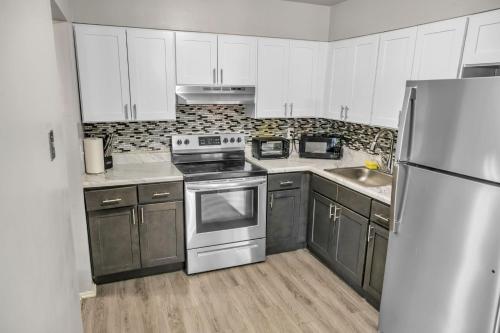 a kitchen with white cabinets and stainless steel appliances at Luxurious 2-bedroom Apartment In Wilmington in Wilmington