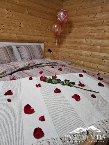 ein Bett mit roten Rosen drauf mit einem Ballon drauf in der Unterkunft Pagony Villa in Galyatető