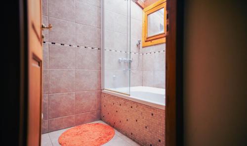 y baño con ducha, bañera y lavamanos. en Sunny en Villa La Angostura