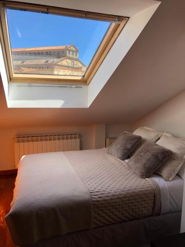 a bedroom with a bed with a large window at Dúplex Sierpes centro parking opcional in Salamanca