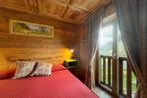 1 dormitorio con cama y ventana grande en Hotel Belvedere, en Cogne