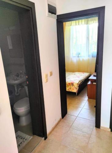 a bathroom with a toilet and a sink and a bed at Apartament Morela in Sunny Beach