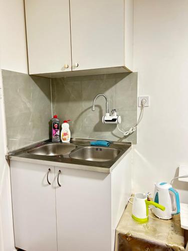 a kitchen with a sink and white cabinets at Sneza in Podgorica