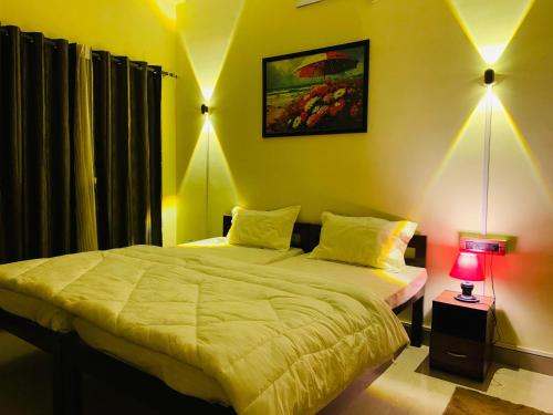 um quarto com 2 camas com um candeeiro e uma fotografia em Moonlight Homestay em Guwahati