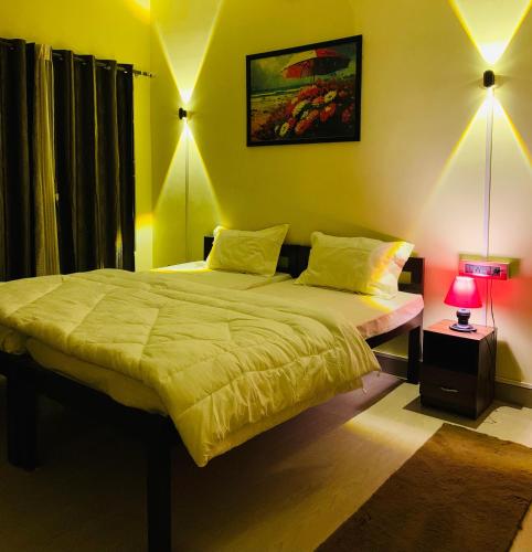 um quarto com 2 camas num quarto com um candeeiro em Moonlight Homestay em Guwahati