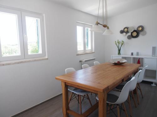 a dining room with a wooden table and chairs at Casal Regina in Sesimbra