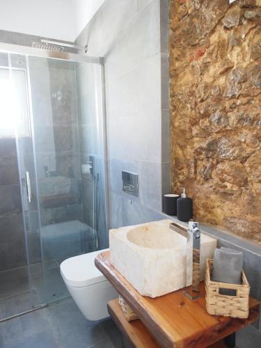 a bathroom with a sink and a shower and a toilet at Casal Regina in Sesimbra