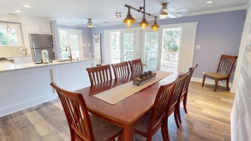 a kitchen and dining room with a wooden table and chairs at 2nd Avenue - Mid Island by Tybee Vacation Rentals in Tybee Island