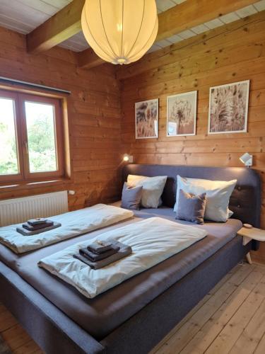 Cama grande en habitación con paredes de madera en Helle und idyllische 2 Zimmer Wohnung am Rande von Berlin, en Berlín