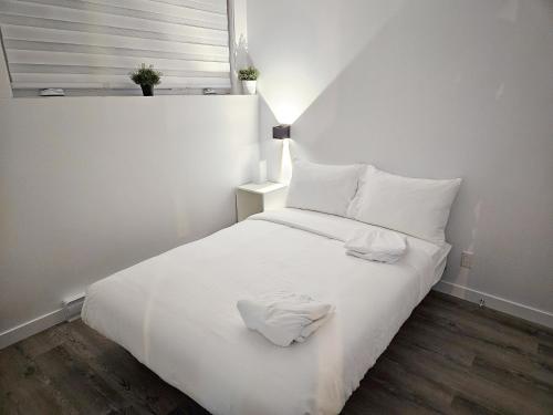białe łóżko z dwoma białymi ręcznikami w obiekcie Le 4 Saisons 4 w mieście Beaupré