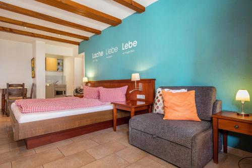 a bedroom with a bed and a chair and a couch at Obst- Ferienhof Ragg in Immenstaad am Bodensee
