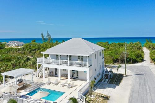 - une vue aérienne sur une maison blanche dotée d'une piscine dans l'établissement The Better Life home, à Governorʼs Harbour