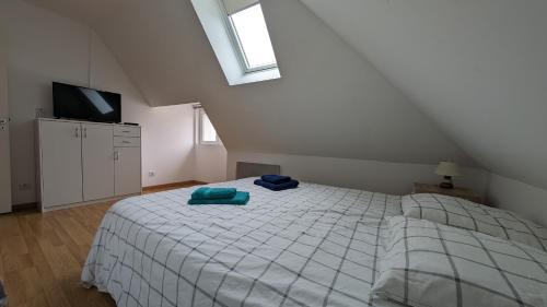 une chambre avec un lit avec deux serviettes bleues dessus dans l'établissement Coastal Breeze Apartment - Equihen-Plage, à Équihen-Plage
