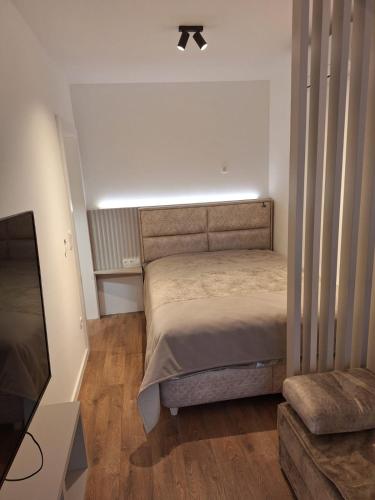 ein kleines Schlafzimmer mit einem Bett und einem Sofa in der Unterkunft Studio apartman M in Posušje