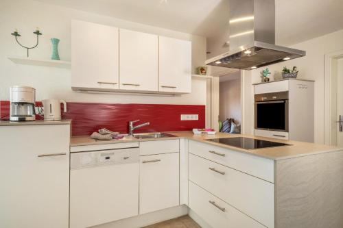 a kitchen with white cabinets and a sink at Obst- Ferienhof Ragg in Immenstaad am Bodensee