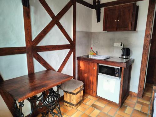 a kitchen with a wooden table and a microwave at Pokoje Gościnne Skalnik in Kostrzyn nad Odrą