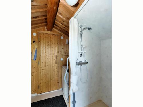 y baño con ducha y paredes de madera. en Holiday home by the lake, en Tived