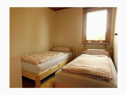 2 camas individuales en una habitación con ventana en Holiday home by the lake, en Tived