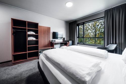 a hotel room with a bed and a window at Blue Hotel Fagrilundur - On The Golden Circle in Reykholt