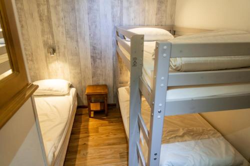 Cette petite chambre comprend 2 lits superposés et une table. dans l'établissement Résidence Les Hauts De Preclaux - Joli studio pour 5 personnes avec vue pistes MAE-0041, aux Orres