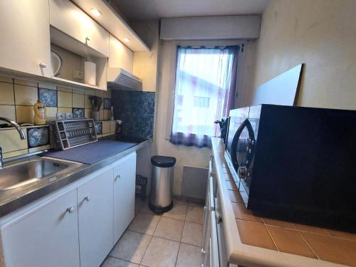 une petite cuisine avec un évier et une fenêtre dans l'établissement Résidence Maison Boncelin - Charmant 2 pièces dans quartier très calme ! MAE-0011, à Aix-les-Bains