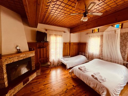 a bedroom with two beds and a fireplace at 9mouses Chasiotis Guest House in Ampelakia