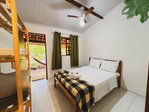 um pequeno quarto com uma cama e uma janela em Hospedagem Donalu - Vale do Capão em Vale do Capao