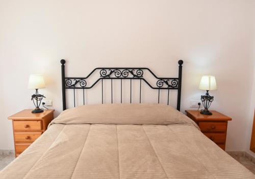 カルプにあるEdificio Seniaのベッドルーム1室(大型ベッド1台、ナイトスタンド2台付)