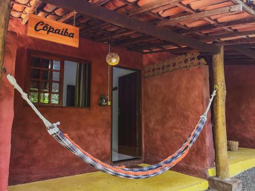 a red wall with a rope tied to a building at Pousada Donalu - Ótima Localização in Vale do Capao