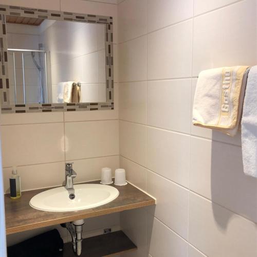 a bathroom with a sink and a mirror and towels at Landgasthof Fischer Veri in Mitterfels