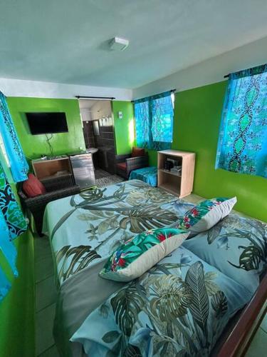 a bedroom with a bed and a green wall at LM Houses 2 in Puahua