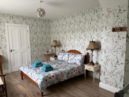 1 dormitorio con cama y papel pintado con motivos florales en Robins Nest en Ardara