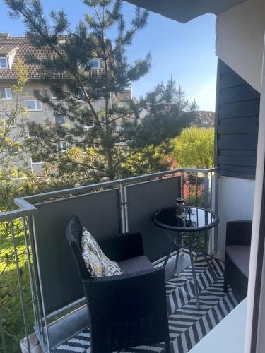 a balcony with chairs and a table and a tree at Promienna Rezydencja - bright holiday home in Wolin