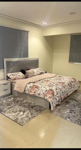 ein Schlafzimmer mit einem Bett und zwei Teppichen in der Unterkunft شقق ريان المفروشه in Riad