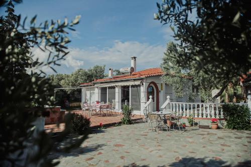 a white house with a patio and tables and chairs at Resort Dimitris in Alexandroupoli