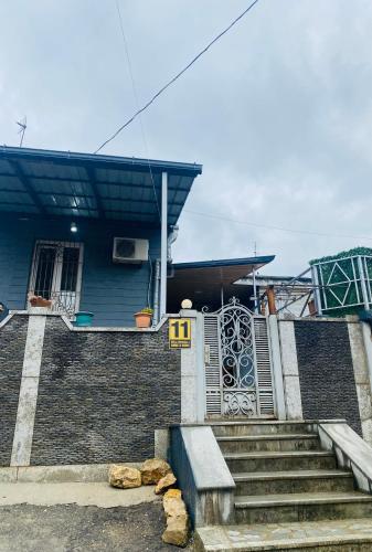 a blue house with stairs and a gate at Anna'S Home in Kutaisi