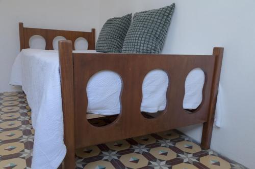 a bed with a wooden foot board with white shoes at Casa Cirila in Santa Cruz de la Palma