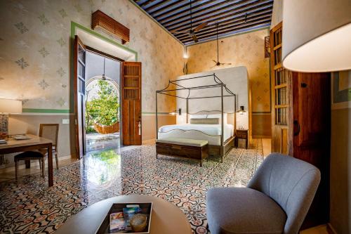 a bedroom with a bed and a desk and a chair at Hacienda San Antonio Hool in Mérida