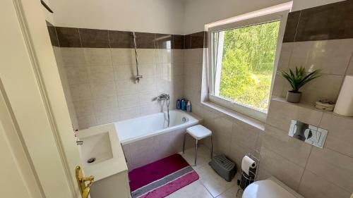 a bathroom with a bath tub and a window at Noclegi Bajama in Siepraw