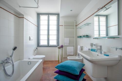 a bathroom with a tub and a sink and a toilet at Villa Laura in Gardone Riviera