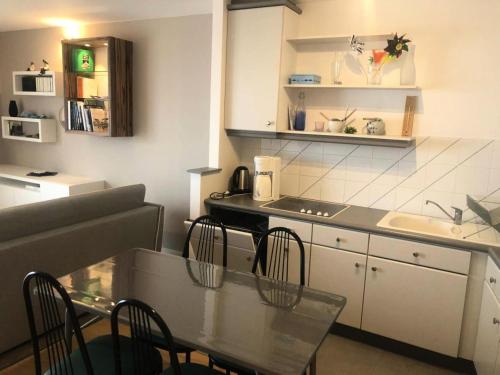 une cuisine avec une table et des chaises dans une cuisine dans l'établissement Résidence Regates - 2 Pièces pour 4 Personnes 061, à Pléneuf-Val-André