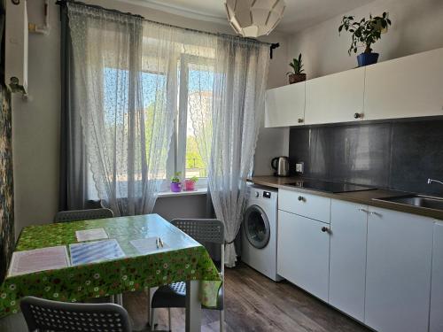 a small kitchen with a table and a laundry room at Studio Gdańsk Wrzeszcz in Gdańsk