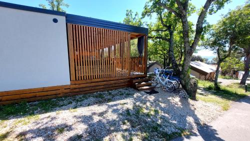 ein Gebäude mit einer Bank neben einem Baum in der Unterkunft MOBIL HOME SELCE in Selce