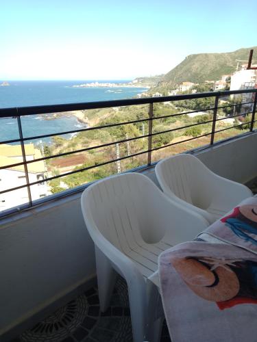 uma varanda com 2 cadeiras e vista para o oceano em إقامة عش الباز ساكت بجاية الجزائر em Taranimt
