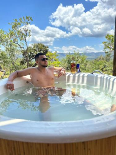 a man sitting in a bath tub at Bangalôs da Montanha in Serra do Cipo