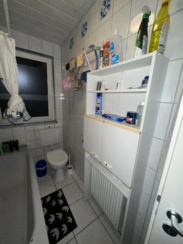 a small bathroom with a toilet and a sink at Modernes und stilvolles Zimmer mit großer Terrasse neben dem Bahnhof in Gießen
